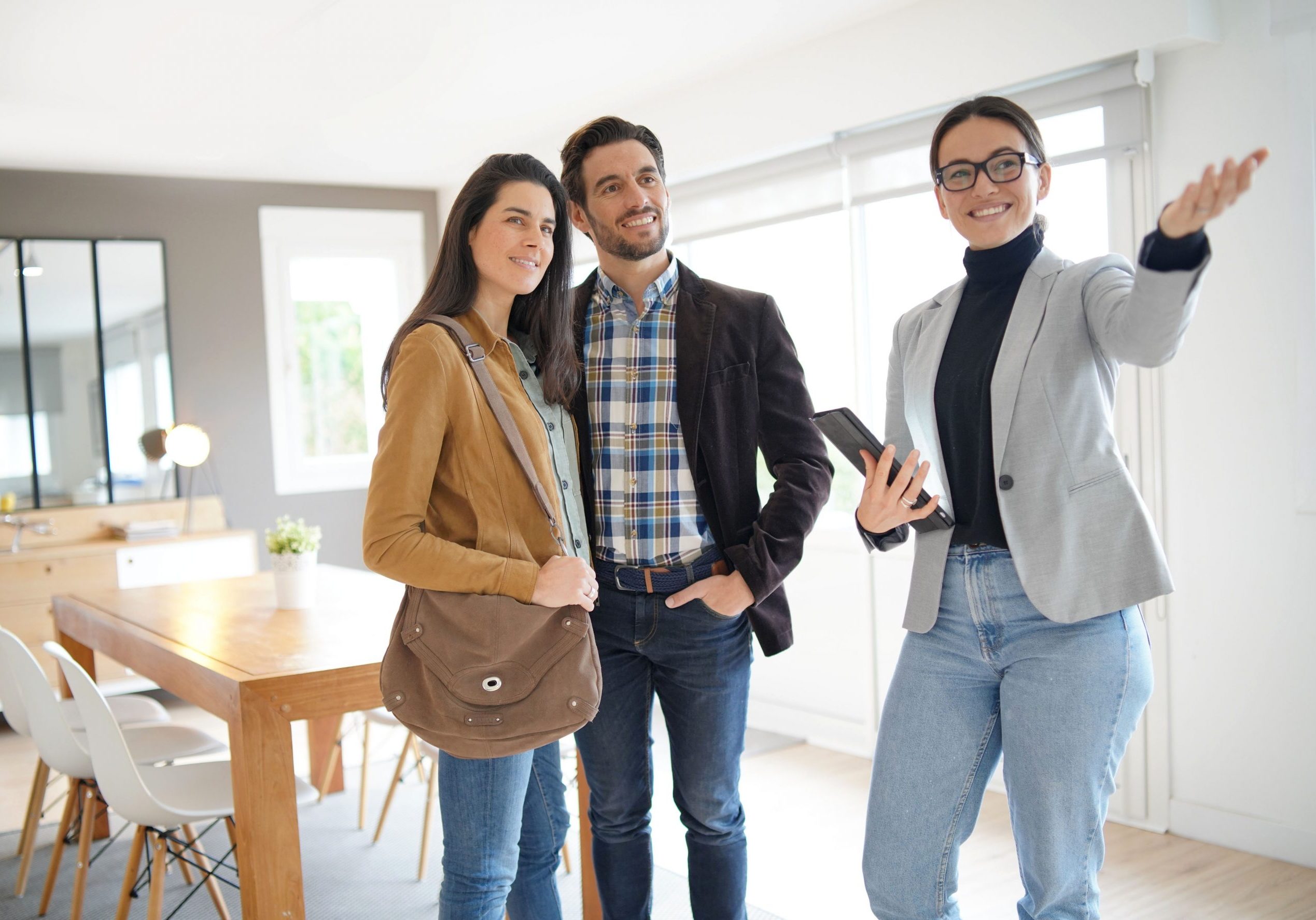 Real estate agent showing modern house to attractive couple